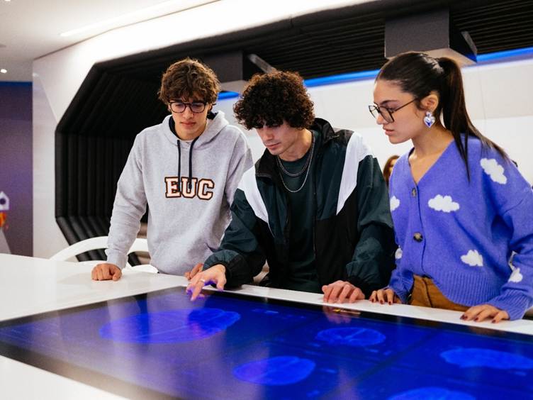 A group of people looking at a touch screen

AI-generated content may be incorrect.